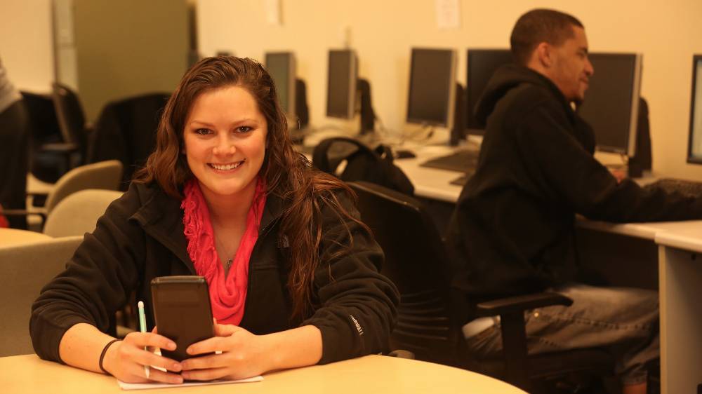 A PennWest California students holds a calculator.