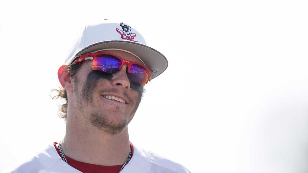 A baseball player looks into the field.